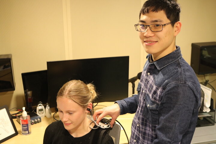 Cheng-Han and Ella demonstrating lab equipment in the sound booth.